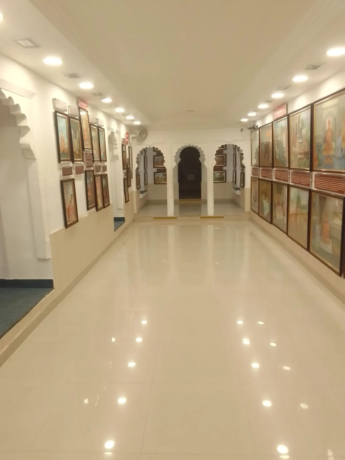 Framed artworks lining the walls of a gallery corridor