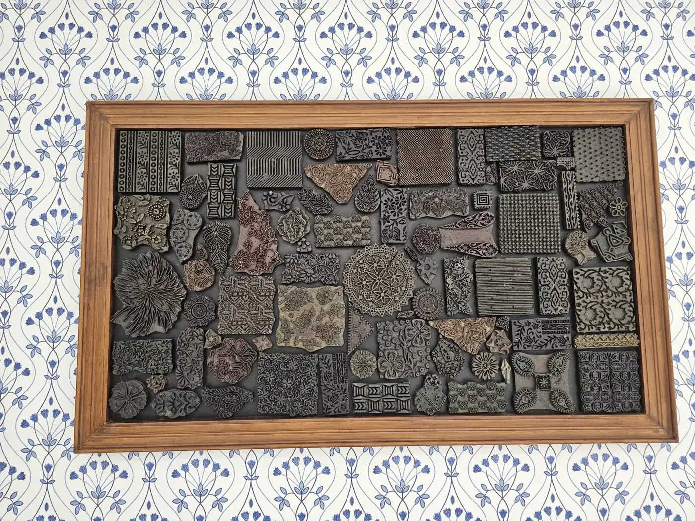Carved relief printing blocks in a wooden frame