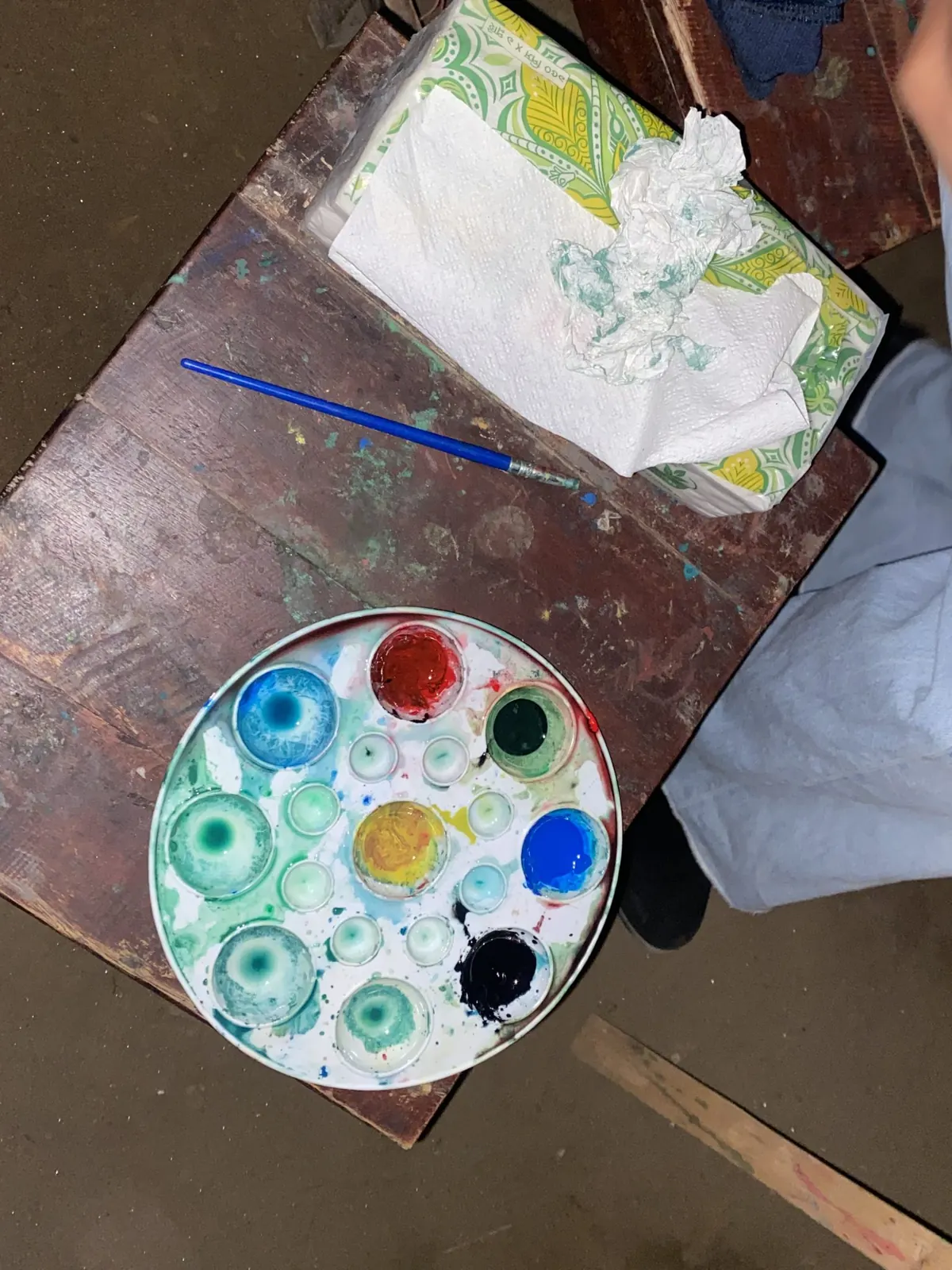 A paint palette and brush on a studio table